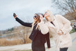 © sergiubirca - Outdoor lifestyle portrait of two best friends, smiling and having fun together, enjoy each other company posing and making selfie pictures to each other and share happiness