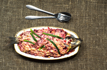  salad herring under a fur coat on a wooden table in the backgro