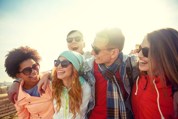 Wall Mural - smiling friends in sunglasses laughing on street