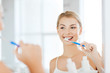 © Syda Productions - woman with toothbrush cleaning teeth at bathroom