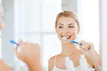 Woman With Toothbrush Cleaning Teeth At Bathroom