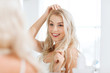 © Syda Productions - happy young woman looking to mirror at bathroom