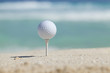 © Daniel Thornberg - Golf ball on tee in sand beach with ocean waves behind