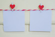 Blank white paper and red clip paper heart hanging on the clothesline with wooden background.Designer concept.