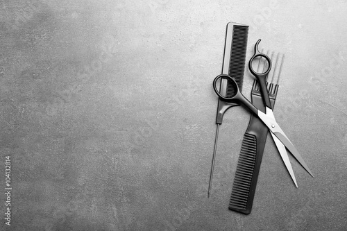 Leinwand Poster Barber set with two combs and scissors on grey background
