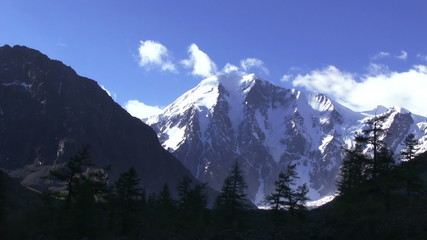 Wall Mural - Alpine landscape. The top of a snowy mountain is hidden in the cloud. Altay, Russia, Maashey-Bashi mountain, North Chui range, altitude 4000 m. 
