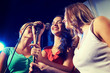 © Syda Productions - happy young women singing karaoke in night club