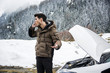 © theartofphoto - Man talking on cellphone next to broken car