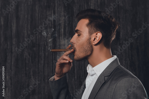 Side view portrait of handsome man in suit smoking a cigar Stock Photo ...