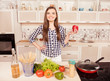 © deagreez - Pretty smiling girl holding red pepper in the kitchen