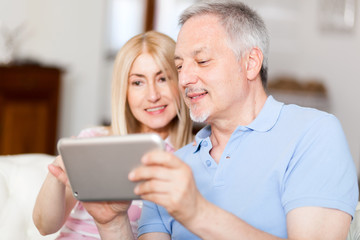 Wall Mural - Couple using a tablet on the sofa