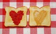 Peanut butter and jelly spread in heart shapes on toast