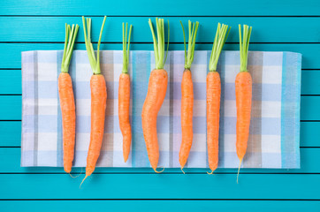 Wall Mural - Fresh carrots on checkered tablecloth