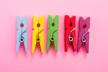 Colored Clothespins On A Pink Background