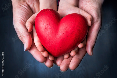 Plakat Czerwone serce na dłoni kobiety i dziecka - Symbol matki dzień