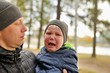 © dojo666 - Baby crying in arms of his father in park