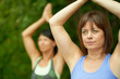 © AYAimages - Two mature women keeping fit by doing yoga in the summer