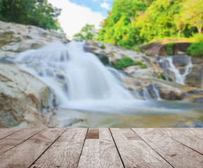 Wood floor top on blurred water fall