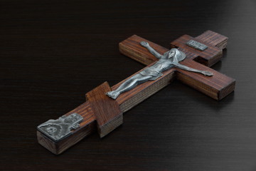 Jesus Christ Figurine Crusified On Wooden Cross On Black Backgro