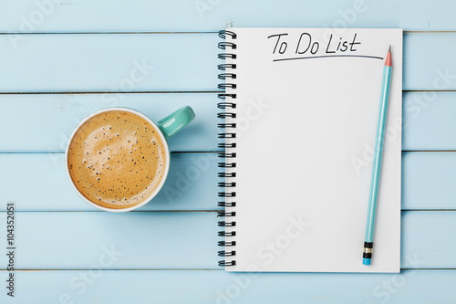 Coffee cup and notebook with to do list on blue rustic desk from above, planning Poster