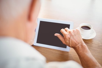 Wall Mural - Elderly man using tablet and drinking coffee