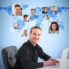 Wall Mural - Composite image of smiling businessman using laptop at desk