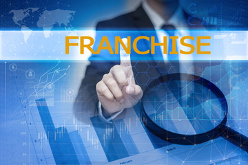 Businessman hand touching FRANCHISE button on virtual screen