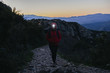© Westend61 - Spain, Catalunya, Girona, female hiker walking with headlamp at twilight