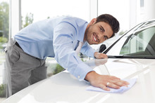 At The Car Dealer, Salesman Cleaning Car Hood