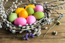 Easter Background, Selective Focus. Homemade Hand Painted Colorful Easter Eggs In Nest From Willow Branches Close-up Over Retro Wooden Rustic Background