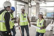 © Westend61 - Woman in protective workwear and construction workers in construction site