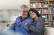 © Westend61 - Smiling mature couple cuddling at home