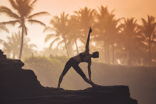 Indonesia, Bali, Woman Practicing Yoga At The Coast At Twilight