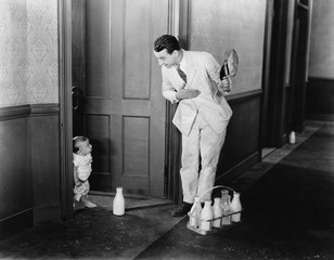 Milkman greeting baby at door 