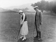© everettovrk - Profile of a couple playing golf in a golf course