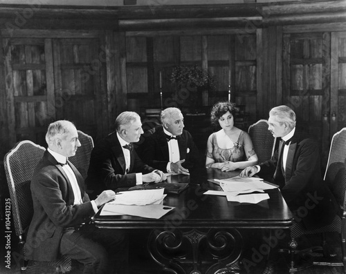 Fotomural Group of men sitting with a young woman in a boardroom