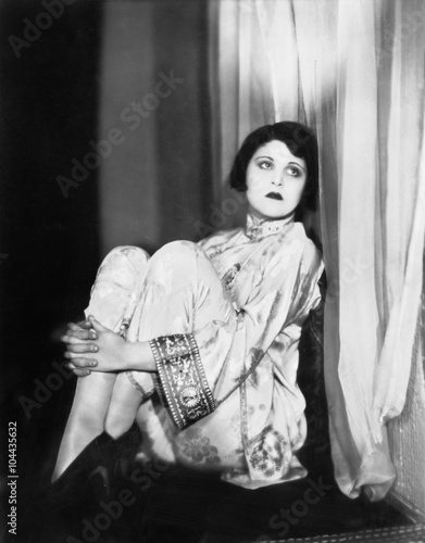 Fotografie, Obraz Woman in a Chinese outfit leaning against a wall