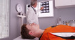 Portrait of young sports athlete lying down while doctor reviews