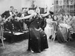 Zaftig woman performing a dance in front of a group of people in a restaurant 