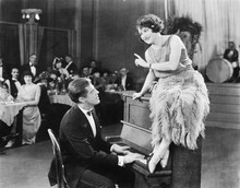 Young Woman Sitting On Top A The Piano And Talking With The Pianist 