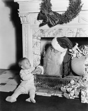 Santa Claus With A Little Boy In Front Of A Fireplace 