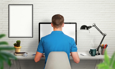 Aufkleber - Man work on office computer with isolated screen for mockup. Modern office interior with isolated poster frame, lamp, plant, coffee, pencils.