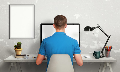 Aufkleber - Man work on office computer with isolated screen for mockup. Modern office interior with isolated poster frame, lamp, plant, coffee, pencils.