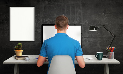 Aufkleber - Man work on office computer with isolated screen for mockup. Modern office interior with isolated poster frame, lamp, plant, coffee, pencils.