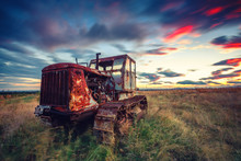 Beautiful Sunset Over Field And Old Rusty Tractor