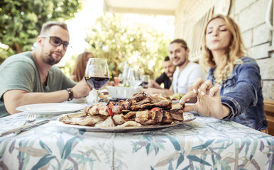 Group of friends making barbeque in the backyard