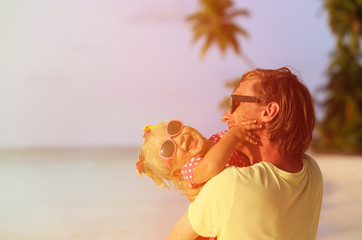 father and cute little daughter at beach