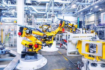 Wall Mural - robotic arms in a car plant