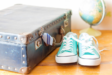 Travel concept with holiday suitcase, shoes and globe
