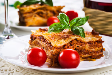 Wall Mural - Piece of tasty hot lasagna with red wine..